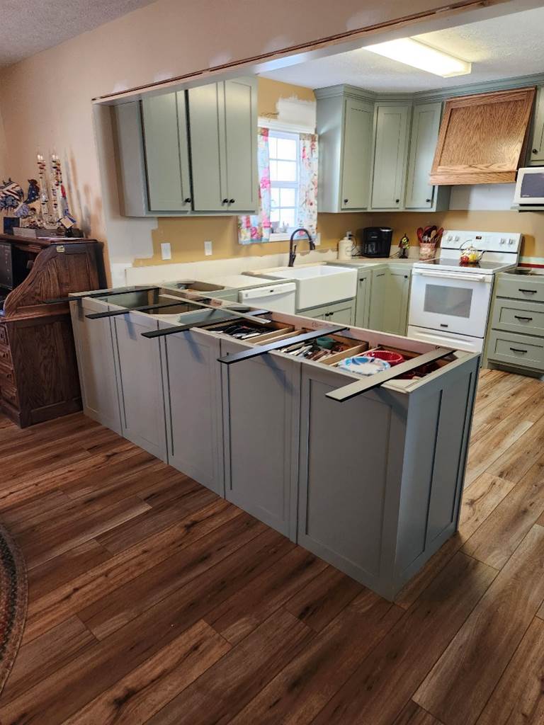 A kitchen with a wood floor

Description automatically generated