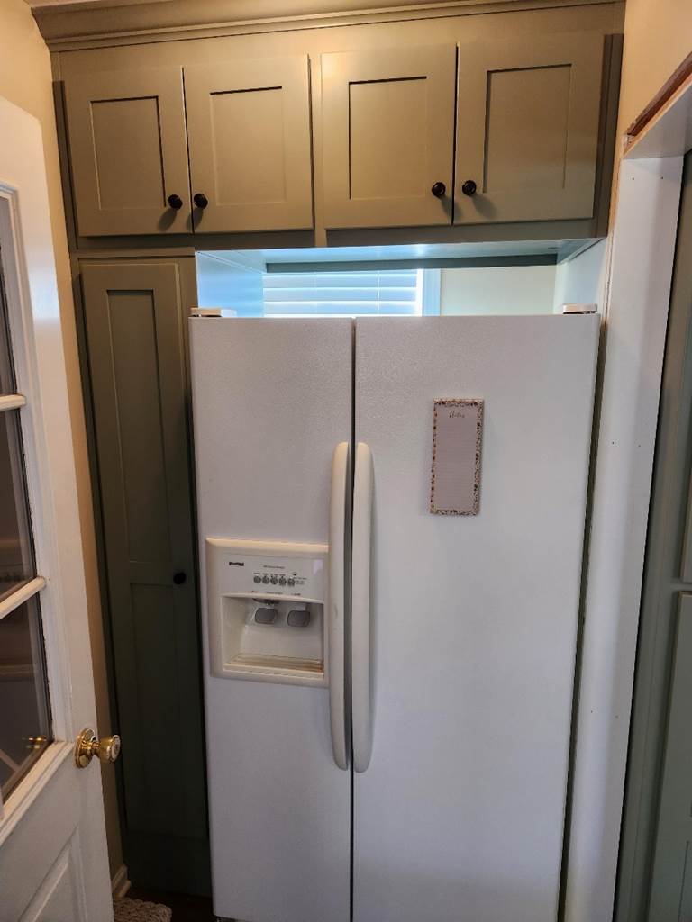 A white refrigerator in a kitchen

Description automatically generated
