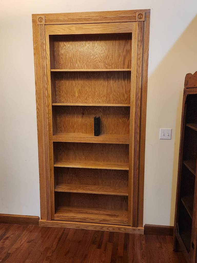 A wooden bookcase in a room

Description automatically generated