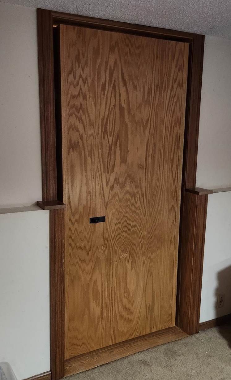 A wooden door in a room

Description automatically generated
