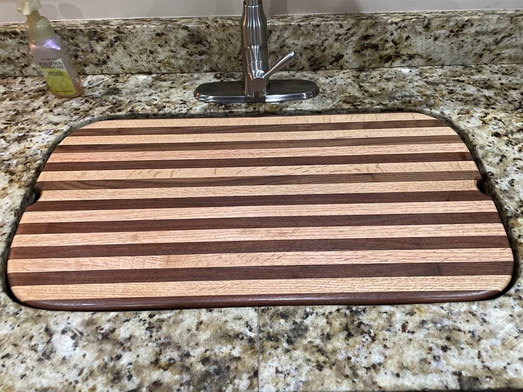 A wooden cutting board on a marble counter top

Description automatically generated