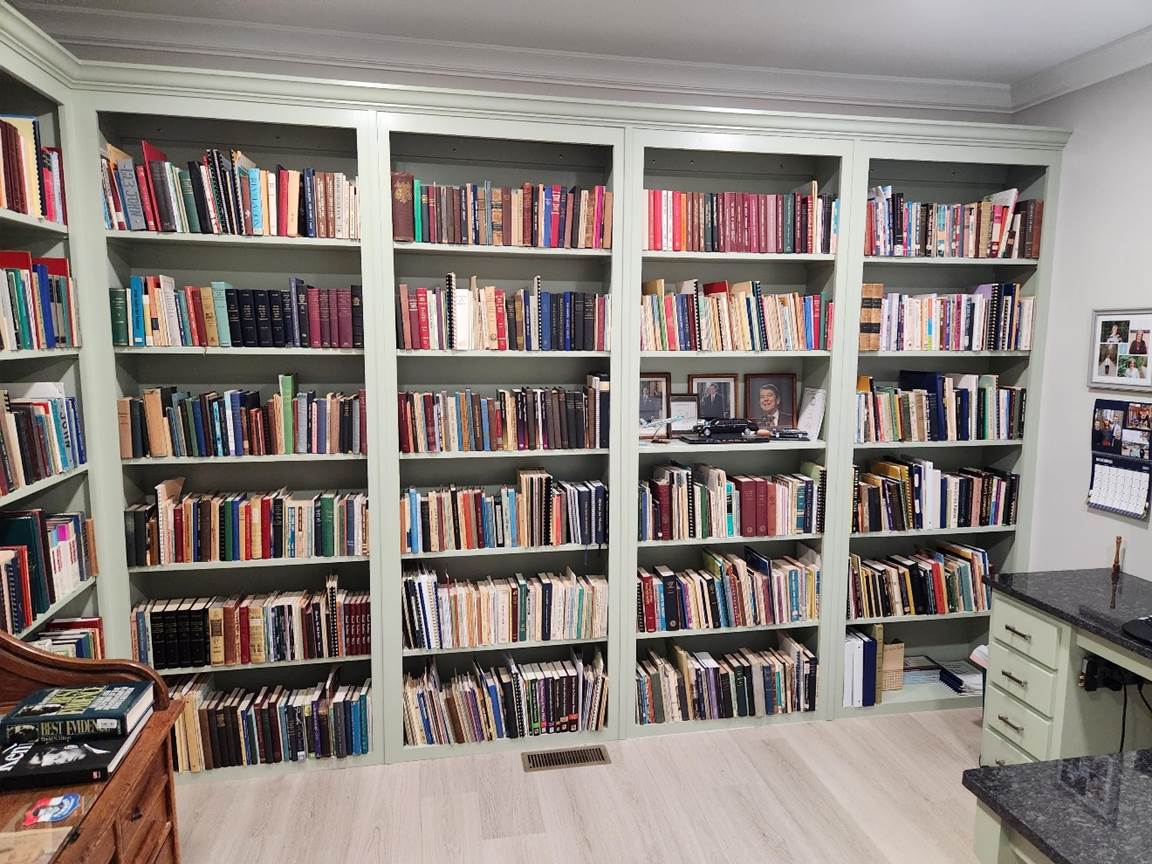A large white bookcase with many books on it

Description automatically generated