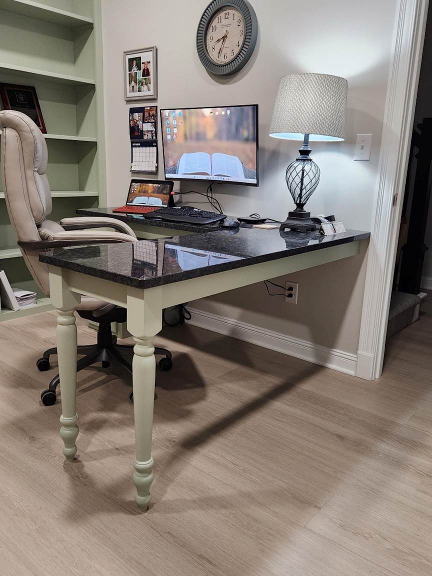 A desk with a lamp and a chair

Description automatically generated