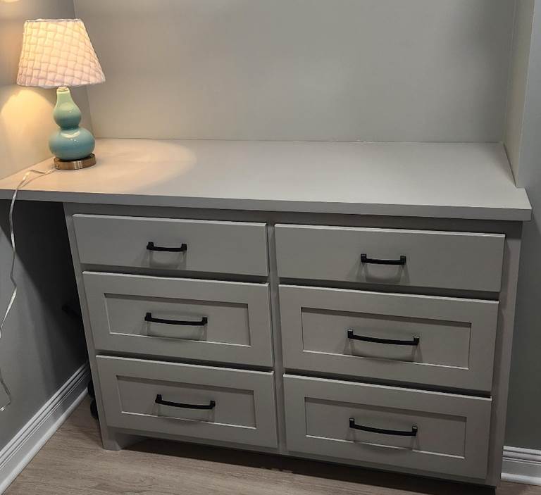 A dresser with a lamp on top

Description automatically generated