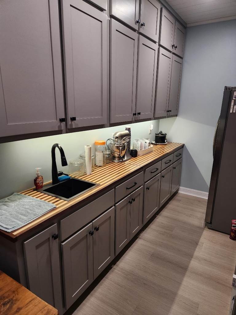 A kitchen with grey cabinets

Description automatically generated