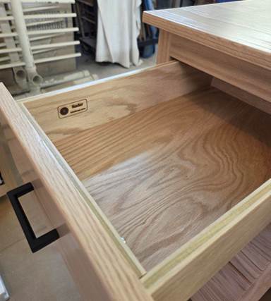 A wooden drawer with a black handle

AI-generated content may be incorrect.